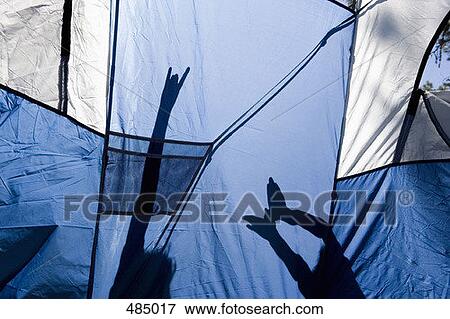 Stock Photo - Children making shadow puppets behind a tent. Fotosearch