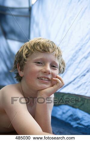Portrait of a young boy in a tent View Large Photo Image Stock Image - Portrait of a young boy in a tent. Fotosearch