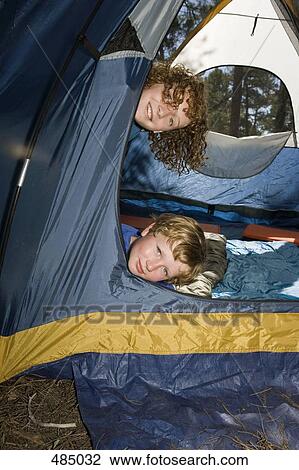 Two young boys peeking out of a tent View Large Photo Image Stock Image - Two young boys peeking out of a tent. Fotosearch