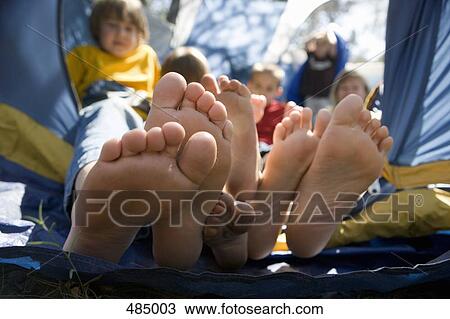 View of children's feet poking out of a tent View Large Photo Image Stock Image - View of children's feet poking out of a tent. Fotosearch