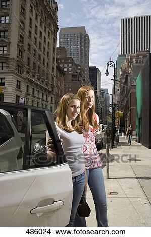 Two adolescent girls standing on the sidewalk View Large Photo Image Picture - Two adolescent girls standing on the sidewalk. Fotosearch