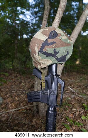 Stock Image - A soldier's helmet hanging from a rifle. Fotosearch