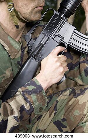Soldier holding a gun View Large Photo Image Stock Image - Soldier holding a gun. Fotosearch