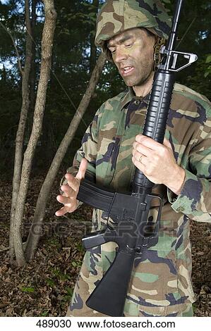 Soldier holding his gun View Large Photo Image Stock Image - Soldier holding his gun. Fotosearch