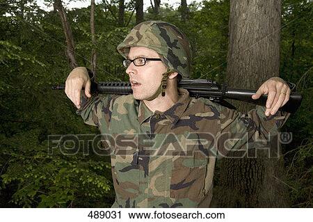 Soldier resting a gun across his shoulders View Large Photo Image Stock Image - Soldier resting a gun across his shoulders. Fotosearch