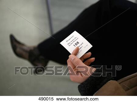 A woman holding a ticket in a waiting room View Large Photo Image Stock Photography - A woman holding a ticket in a waiting room. Fotosearch