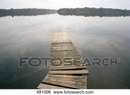 A small wooden jetty out to a lake View Large Photo Image Stock Photograph - A small wooden jetty out to a lake. Fotosearch