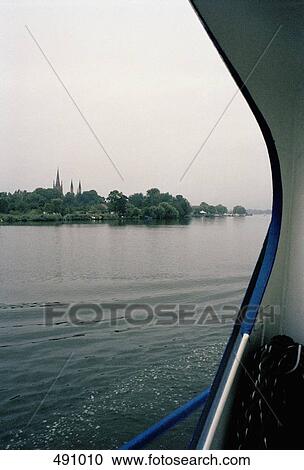 View from a passenger boat of a village by a river View Large Photo Image Stock Image - View from a passenger boat of a village by a river. Fotosearch