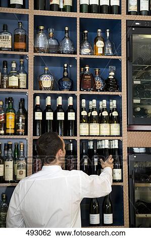 A bar man choosing a bottle of wine View Large Photo Image Stock Image - A bar man choosing a bottle of wine. Fotosearch