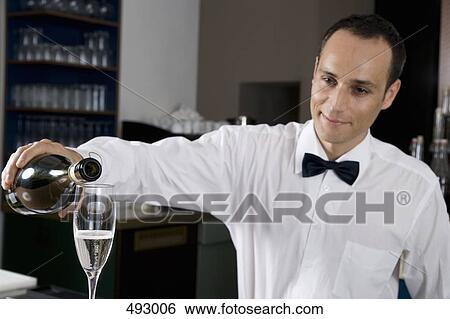 A bar tender pouring a glass of champagne View Large Photo Image Stock Photograph - A bar tender pouring a glass of champagne. Fotosearch