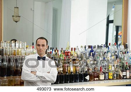 Stock Image - A bar tender standing at the bar. Fotosearch