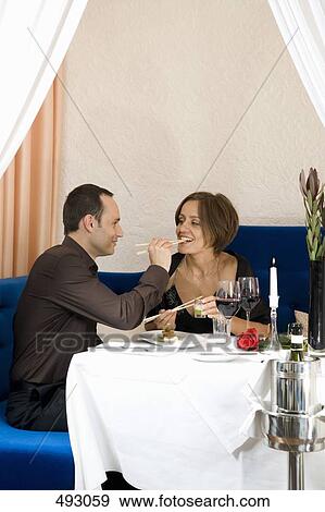 A couple feeding each other sushi in a restaurant View Large Photo Image Stock Photo - A couple feeding each other sushi in a restaurant. Fotosearch