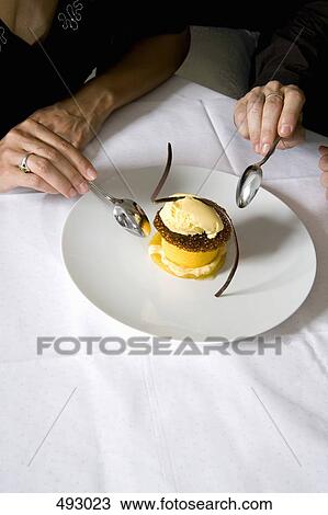 A couple sharing a dessert in a restaurant View Large Photo Image Stock Image - A couple sharing a dessert in a restaurant. Fotosearch