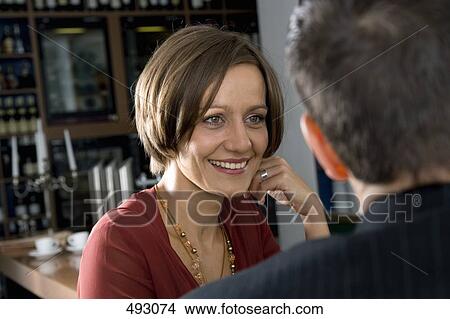 A couple sitting at a bar View Large Photo Image Picture - A couple sitting at a bar. Fotosearch