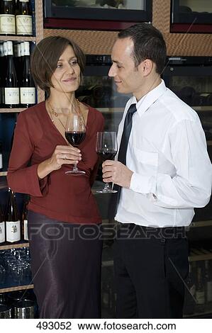 Stock Image - A couple wine tasting. Fotosearch