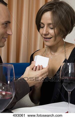 A man giving a woman a ring in a restaurant View Large Photo Image Stock Image - A man giving a woman a ring in a restaurant. Fotosearch