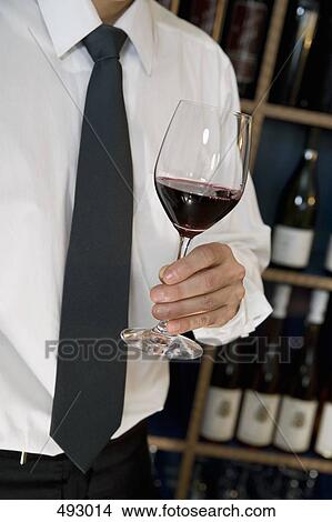 A man holding a glass of wine View Large Photo Image Picture - A man holding a glass of wine. Fotosearch