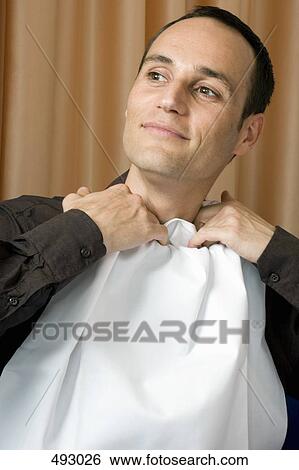 A man tucking a napkin into his shirt collar View Large Photo Image Stock Photograph - A man tucking a napkin into his shirt collar. Fotosearch