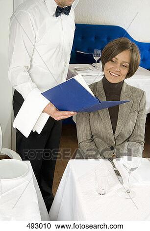 A waiter showing the menu to a woman View Large Photo Image Stock Image - A waiter showing the menu to a woman. Fotosearch