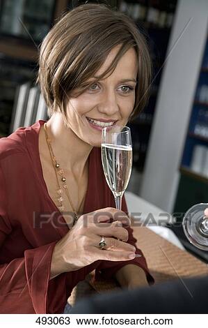 A woman drinking champagne in bar View Large Photo Image Stock Image - A woman drinking champagne in bar. Fotosearch