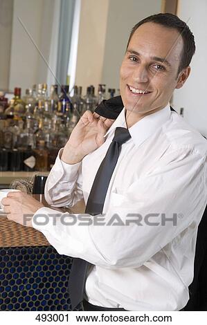 Stock Image - Businessman drinking espresso at a bar. Fotosearch