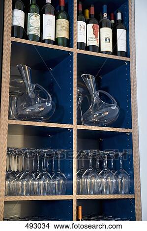 Wine bottles and glasses on shelves View Large Photo Image Picture - Wine bottles and glasses on shelves. Fotosearch