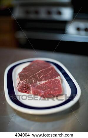 Picture - A steak on a plate in a kitchen. Fotosearch