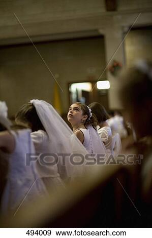 A young girl looking up at her holy communion ceremony View Large Photo Image Stock Photo - A young girl looking up at her holy communion ceremony. Fotosearch