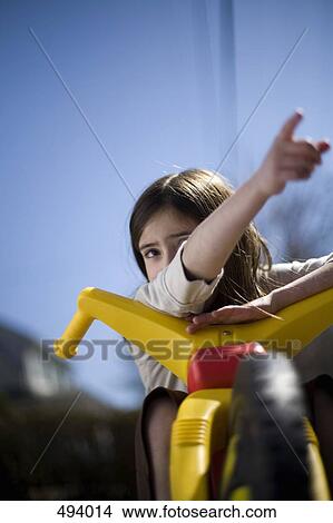 A young girl sitting on a tricycle and pointing View Large Photo Image Picture - A young girl sitting on a tricycle and pointing. Fotosearch