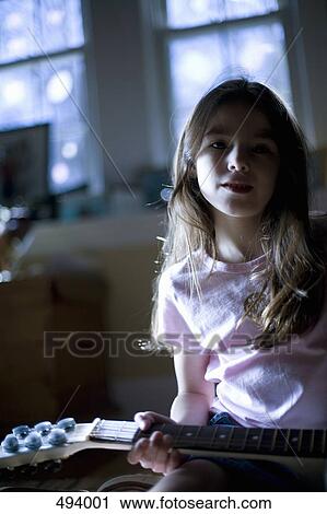 A young girl sitting with a guitar View Large Photo Image Stock Image - A young girl sitting with a guitar. Fotosearch