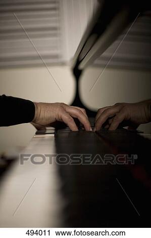 Stock Image - Detail of a man playing a piano. Fotosearch