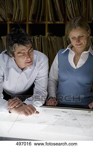 A businessman and a businesswoman standing over a light box View Large Photo Image Stock Photograph - A businessman and a businesswoman standing over a light box. Fotosearch