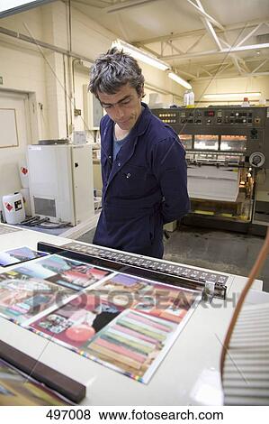 A man looking at printed samples in a factory View Large Photo Image Stock Photo - A man looking at printed samples in a factory. Fotosearch
