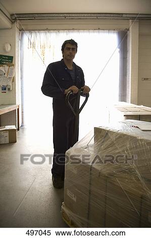 A man standing in a warehouse behind a forklift View Large Photo Image Stock Photography - A man standing in a warehouse behind a forklift. Fotosearch