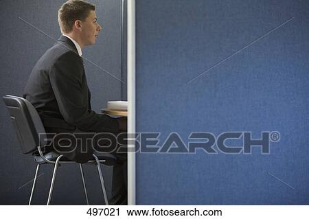 A young businessman in a meeting in an office cubicle View Large Photo Image Stock Image - A young businessman in a meeting in an office cubicle. Fotosearch