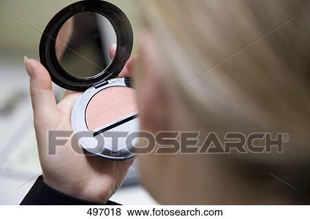 Stock Photo - Detail of a woman holding a pressed powder compact. Fotosearch