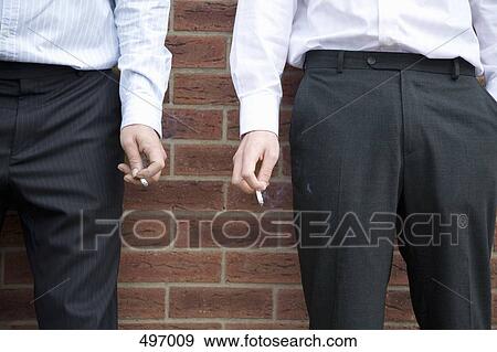 Stock Photo - Midsection of two businessmen smoking. Fotosearch