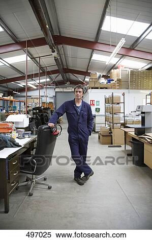 Stock Photography - Portrait of a worker standing in a factory. Fotosearch