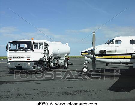An airplane being refueled on a runway View Large Photo Image Stock Photograph - An airplane being refueled on a runway. Fotosearch