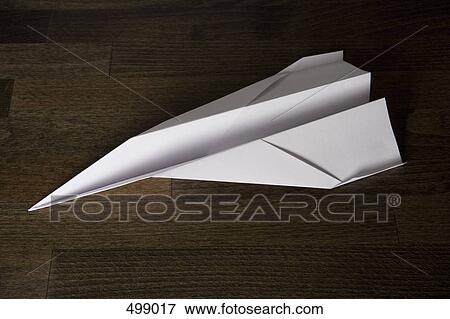 Stock Photo - A paper plane on a wooden table. Fotosearch