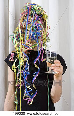 Stock Image - A woman covered in streamers and holding a glass of champagne. Fotosearch