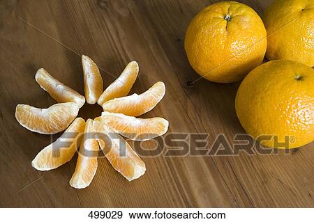 Stock Photo - Oranges and orange segments arranged on a table. Fotosearch