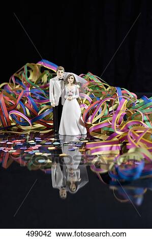 Streamers and confetti surrounding a figurine of a bride and groom View Large Photo Image Stock Image - Streamers and confetti surrounding a figurine of a bride and groom. Fotosearch