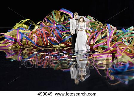 Streamers and confetti surrounding a figurine of a bride and groom View Large Photo Image Stock Photo - Streamers and confetti surrounding a figurine of a bride and groom. Fotosearch
