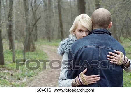 Stock Photo - A couple hugging in a forest. Fotosearch
