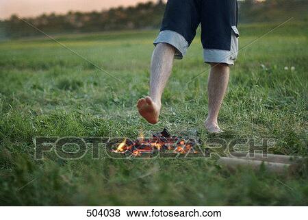 A man standing with his bare foot above a campfire View Large Photo Image Stock Photo - A man standing with his bare foot above a campfire. Fotosearch