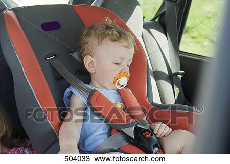 Stock Image - A young boy sleeping in the back seat of a car. Fotosearch