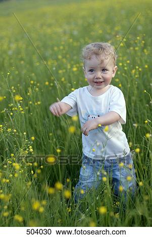 A young boy standing in a field View Large Photo Image Stock Image - A young boy standing in a field. Fotosearch