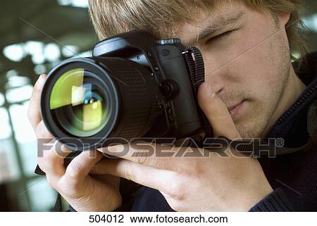 A young man taking a photograph View Large Photo Image Stock Image - A young man taking a photograph. Fotosearch