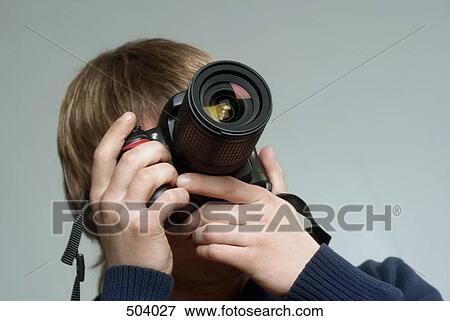A young man taking a photograph View Large Photo Image Stock Photo - A young man taking a photograph. Fotosearch